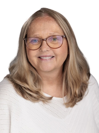 Studio headshot of a smiling woman with shoulder-length blonde hair and glasses, wearing a white sweater against a white background.